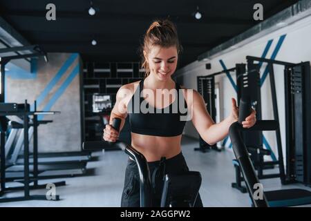 Always positive girl having exercise. Photo of gorgeous blonde woman in the gym at her weekend time Stock Photo