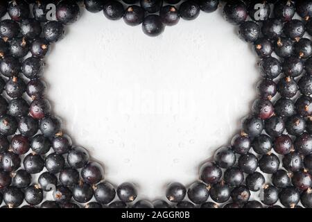 Heart shapes made of black currant berries on white background. Top view. Flat lay. cardiology concept, healthy heart. Stock Photo