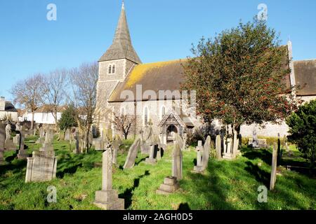 A beautiful old church and grave yard with a holly tree full of red berries in Hove, Brighton, East Sussex, united kingdom, the grave tombs are in the Stock Photo