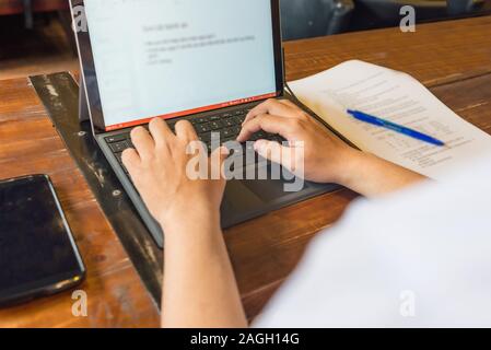 Close up photo of young man typing on laptop Stock Photo