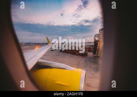 The view from the window of the airplane porthole at dawn at the airport of Barcelona. Theme of romance on a journey. Tourism and air travel. View Stock Photo