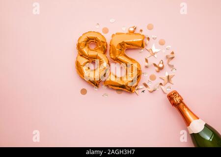 Happy 85th anniversary party. Champagne bottle with gold number balloon. Stock Photo