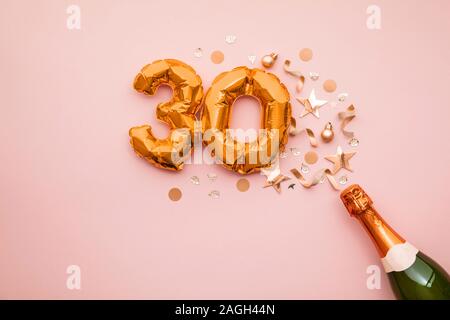 Happy 30th anniversary party. Champagne bottle with gold number balloon. Stock Photo
