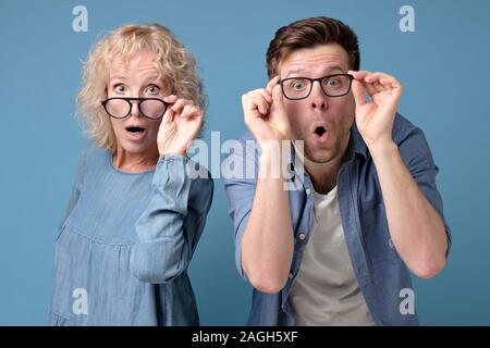 man and woman look with widely opened mouth into camera in full disbelief. Stock Photo