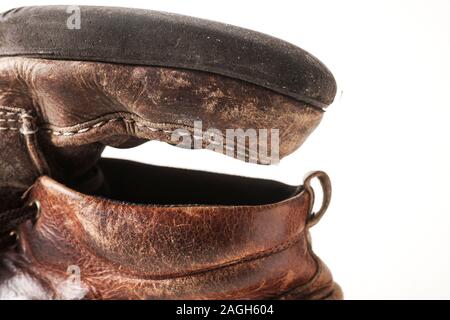 Photograph of man's dirty old leather boots on white background Stock Photo