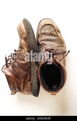 Photograph of man's dirty old leather boots on white background Stock Photo