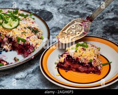 In Ukraine, one of the most popular holiday dishes is a salad called 'Herring under a fur coat.' It is made from slightly salted herring, boiled potat Stock Photo