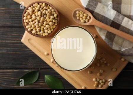 Glass of soy milk and soybeans seeds on wooden background, space for text. Top view Stock Photo