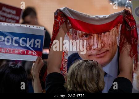 Moscow, Russia. 19th of December, 2019 A journalist holds a shawl with portrait of Russian President Vladimir Putin during the annual news conference, in Moscow, Russia