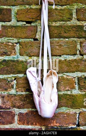 pair of ballet shoes hanging on  wall Stock Photo