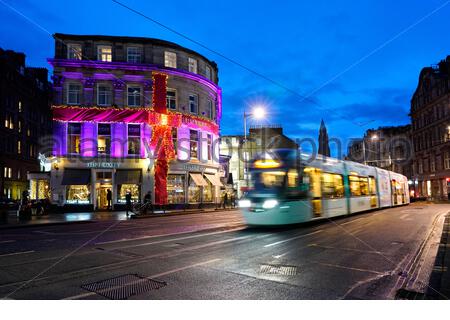 Edinburgh, Scotland, UK. 19th  Dec 2019. Dusk as a tram passes the Huxley bar and Restaurant decorated in Christmas lights in Shandwick Place in the West End. Credit: Craig Brown/Alamy Live News Stock Photo