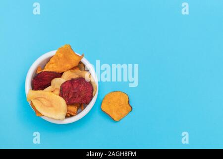 Various handmade vegetable chips on blue background Stock Photo