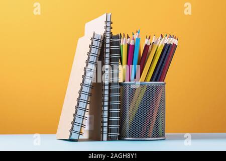 Various notebooks and pencils on a colored background Stock Photo