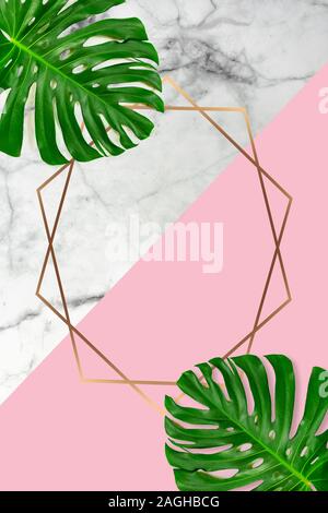 Marble pastel pink background with monstera leaf leaves and golden shape frame for text Stock Photo