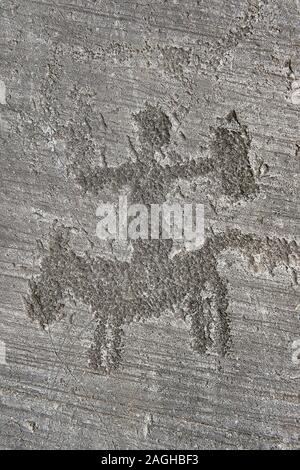 Petroglyph, rock carving, of a warrior riding a horse. Carved by the ancient Camuni people in the iron age between 1000-1200 BC. Rock no 6, Foppi di N Stock Photo