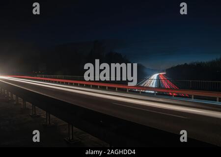 Motorway at night with car light trails Stock Photo