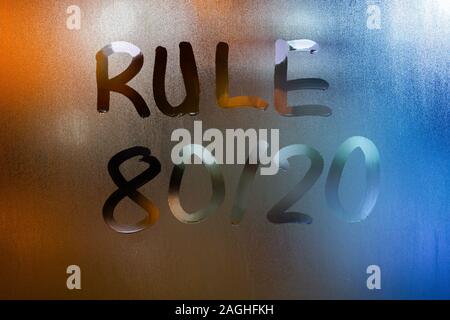 the phrase rule 80 by 20 - pareto principle - handwritten on classic blue night wet window glass with selective focus and blur Stock Photo