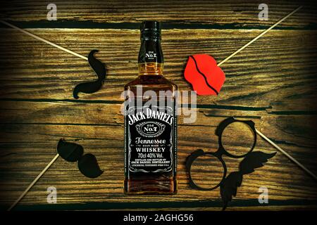 Tanakajd, Hungary - 112. 11. 2019 : Bottle of Jack Daniel's whiskey on weathered wooden background with playfu party photo accessories Stock Photo
