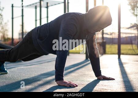 Sport, exercising, training concept. Young man doing push ups or plank exercise Stock Photo