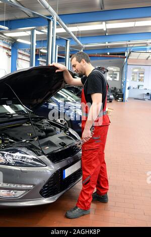 job and workplace - mechanic in a workshop repairing a car Stock Photo