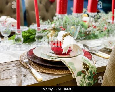 Elegant Christmas dinner table decoration, with dishes, glasses and candles Stock Photo