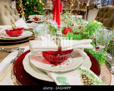 Elegant Christmas dinner table decoration, with dishes, glasses and candles Stock Photo