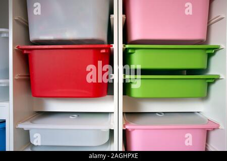 Stack of plastic storage boxes in different colors, sorting system arrangement Stock Photo