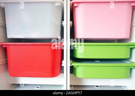Stack of plastic storage boxes in different colors, sorting system arrangement Stock Photo