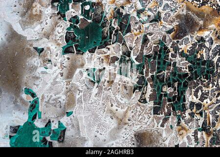 Dirty black old rusty metal surface. White and green paint cracked and bounced. Abstract colorful texture background. Stock Photo