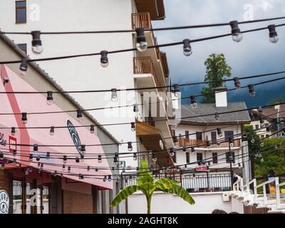 A lot of light bulbs hanging on street in a cafe. Russia Sochi 08 04 2019 Stock Photo