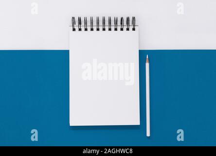 Open notepad and pencil on a blue and white background, with copy space Stock Photo