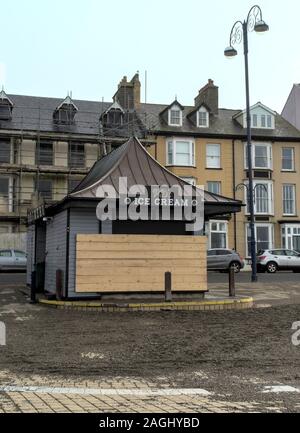 Local beach side cafe (PD Diner) boarded up as a defence against high tidal waves over the winter.  In front is sand washed ashore by recent storm Stock Photo