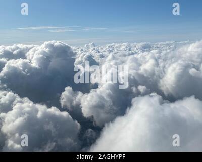 Flight over clouds from above by plane Stock Photo
