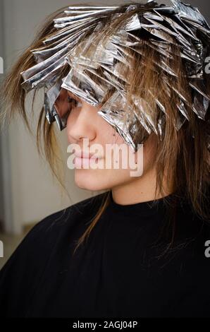 Woman coloring her hair with foil in beauty salon Stock Photo - Alamy