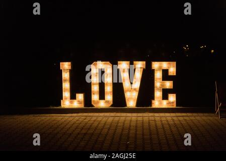 Illuminated Love sign in large letters at a wedding reception. Stock Photo