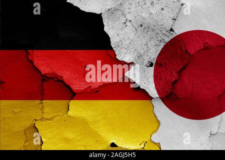 flags of Germany and Japan painted on cracked wall Stock Photo