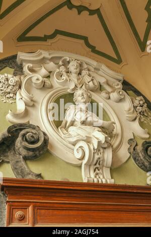 Entrance door decorate with sculpture in the famous double-flight staircase of the Palazzo dello Spagnolo, Naples, designed by the Baroque architect F Stock Photo