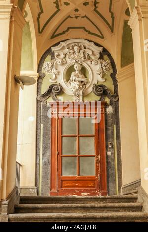 Entrance door decorate with sculpture in the famous double-flight staircase of the Palazzo dello Spagnolo, Naples, designed by the Baroque architect F