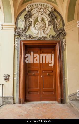 Entrance door decorate with sculpture in the famous double-flight staircase of the Palazzo dello Spagnolo, Naples, designed by the Baroque architect F Stock Photo