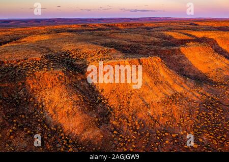 A remote Australian desert sunset near Kings Creek in central Australia. The George Gill Ranges dominate the landscape. Stock Photo