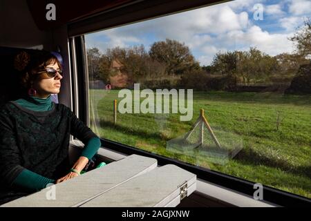 Girl traveling in train with reflection on wiindow Stock Photo