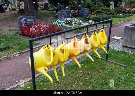 Watering cans in a cemetery Stock Photo