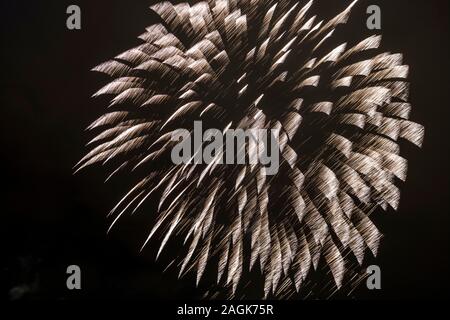 Beautiful fireworks at the dark sky over the town, seen from the meadows along the river Elbe Stock Photo