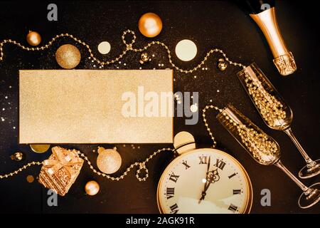 Golden Christmas items and decorations, glasses, champagne, watches. Christmas celebration concept. Flat lay Stock Photo