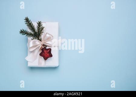 Gift with Christmas decor in white boxes on a blue background. Minimalism, Flat lay, top view, copy space Stock Photo