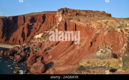 Trekking on the red mountain near red beach on Santorini Island, Greece. Stock Photo