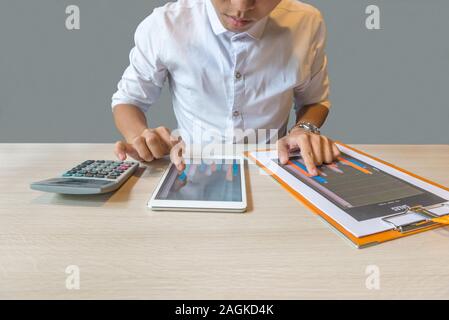 Accountant checking financial number on chart in tablet and document Stock Photo