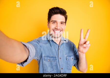 Photo of cheerful positive attractive man showing you v-sign smiling toothily brown haired taking selfie isolated vivid color background Stock Photo
