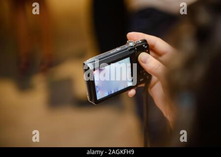 Photo camera in hand taking pictures at wedding party Stock Photo