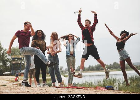 Let's go crazy. Group of people have picnic on the beach. Friends have fun at weekend time